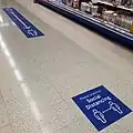 Social distancing floor signs in an Irish supermarket in August 2020.