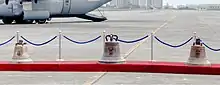 The Balangiga bells on display during a repatriation ceremony at Villamor Air Base. The left bell had been kept by the Army's 9th Infantry Regiment at Camp Red Cloud in South Korea; it is the smallest of the three. The bell in the center is the largest; it and the right bell had been displayed at the F.E Warren Air Force Base's Trophy Park in Cheyenne, Wyoming.