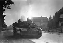 A large mechanised vehicle drives down a suburban road