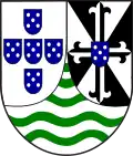 Portuguese Timor(1935–1975)Gyronny of 8, black and white. In the center a cross, colors inverted, which ends in fleurs-de-lys. On the cross a blue shield with white disks.