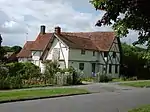 39 The Causeway is a late 14th-century timber-framed house, extended in the 15th and 17th centuries. It is Grade II* listed. A cruck frame and an external bread oven are visible in the gable wall nearest the camera.