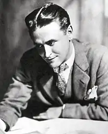 A photograph of writer F. Scott Fitzgerald sitting at a desk.