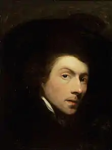Highlighted face of a solemn young man, surrounded by a dark background.