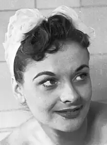 A 23-year-old woman with brown hair smiling to the right of the camera