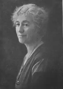 A black and white photograph of the upper torso of a woman
