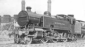 A black-and-white photograph of a 2-6-4 tank locomotive in three-quarter view. The side tank closest to the camera has the word "Metropolitan" painted on it.