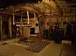 Elaborate interior entirely lined in thatch and matting, with central hearth