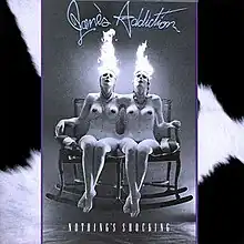 black and white photo of nude female conjoined twins with their heads on fire.