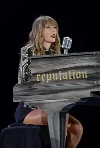 Taylor Swift singing on a piano