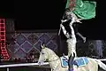 Image 12Turkmen man and his son hoist the flag of Turkmenistan while on horseback at the opening ceremony for the 2008 World Nomad Games. (from Culture of Turkmenistan)