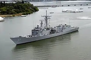 Sailors aboard USS Crommelin (FFG-37) man the rails as the ship passes the Arizona Memorial in Pearl Harbor, 12 May 2004.