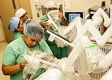Image 56Medical personnel place sterilized covers on the arms of the daVinci Xi surgical system, a minimally-invasive robotic surgery system, at the William Beaumont Army Medical Center. (from History of medicine)