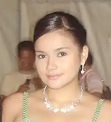 A brown-haired woman in a patterned blue, purple and red dress